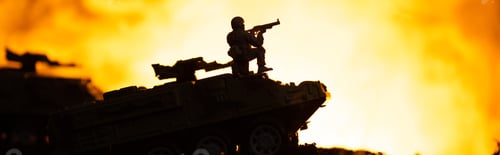 Preview: Battle scene with silhouette of toy soldier on tank with fire at background, panoramic shot