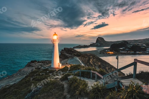 Preview: View of Castlepoint Lighthouse with beam on Wairarapa coast in the evening at New Zealand