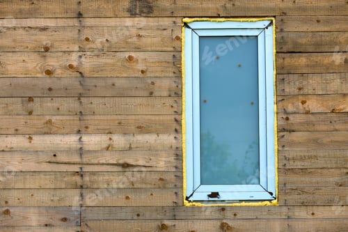 Preview: Close-up detail of new narrow plastic vinyl window installed in house wall of natural wooden planks