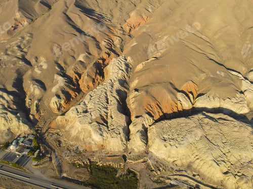 Preview: Overhead shot of deep canyon dividing brown and yellow eroded hills