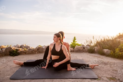 Preview: Couple practicing partner yoga outdoors at sunset