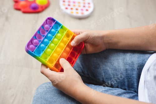 Preview: Colorful anti-stress fidget push pop it sensory toys for children. Boy playing with toys