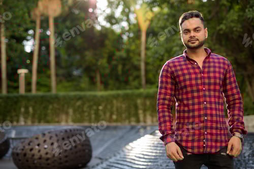 Preview: Young bearded Indian businessman relaxing at the mall in Bangkok