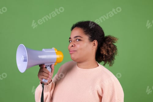 Preview: Beautiful african american woman on green background with megaphone confident cute smile