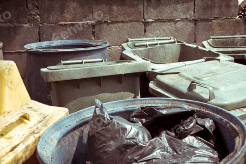 Dumpsters and Trash Cans Against a Brick Wall