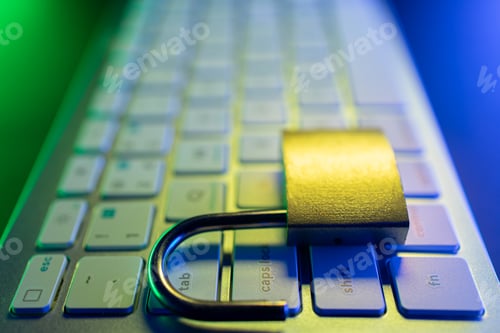 Preview: Security lock placed on a computer keyboard at night with colored lights