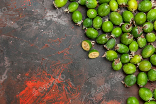 Preview: Above view of fresh natural whole and cut green feijoas small vitamin bomb on dark background