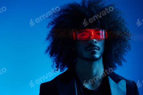 Preview: Fashion portrait of a man with curly hair on a blue background wearing red sunglasses, multinational