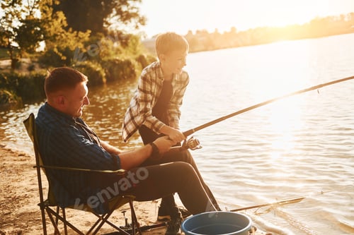 Preview: Conception of hobbies. Father and son on fishing together outdoors at summertime