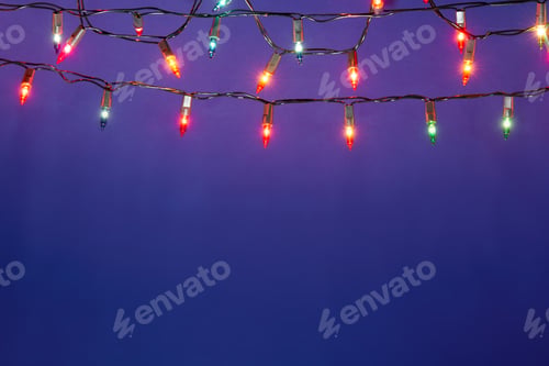 Preview: Christmas lights string on blue background with copy space