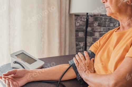 Preview: Senior elder woman measure high low blood pressure test holding using medical