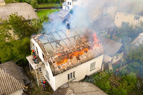 Preview: Aerial view of a house on fire with orange flames and white thick smoke