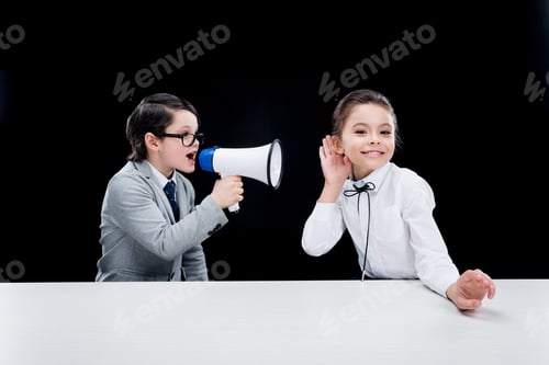 Preview: Boy and girl in formal wear interacting with bullhorn isolated on black
