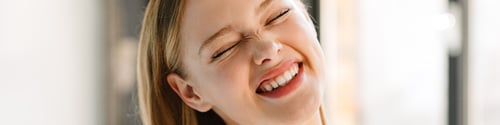 Preview: Young blonde white woman laughing while posing at camera indoors