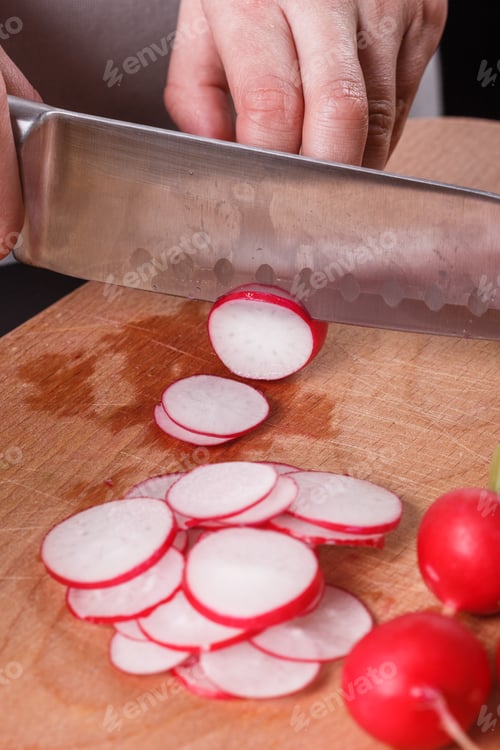 Preview: young woman in a gray apron cuts a radish