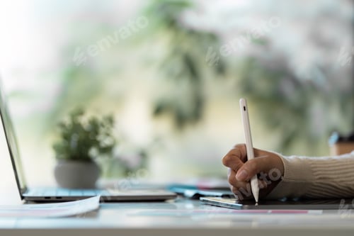 Preview: Creative Designer Working on Digital Tablet with Stylus in Modern Office Environment
