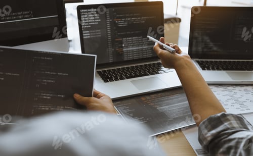 Preview: Two software developers are using computers to work together with their partner at the office desk.