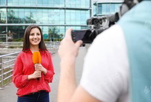 Preview: Young journalist and video operator working on city street