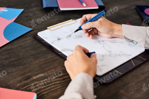 Preview: Hand of young manager or business coach with blue highlighter over blank paper