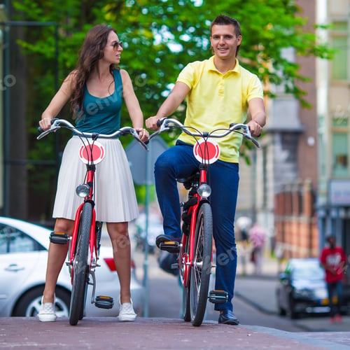 Preview: Young happy caucasian couple on bikes in Amsterdam