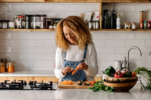 Preview: Woman preparing food in kitchen.