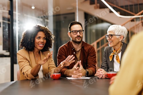 Vista previa: Empresarios sonrientes teniendo una reunión en la oficina, haciendo algunos planes.