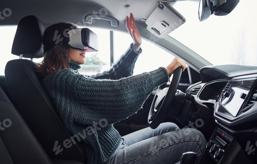 Preview: Side view of woman in virtual reality glasses that sitting inside of modern car