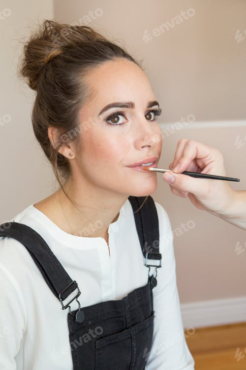 Preview: A young woman getting her makeup touched up before a photoshoot.