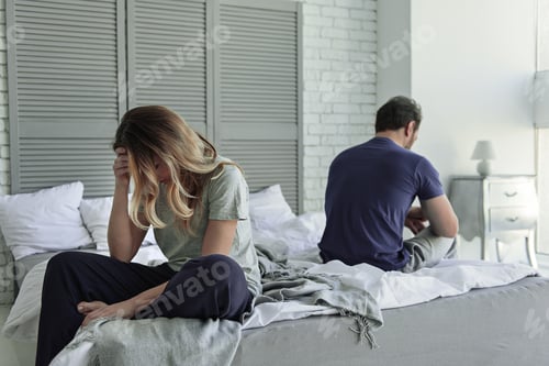 Preview: Unhappy Woman with Man on Bed Indoors