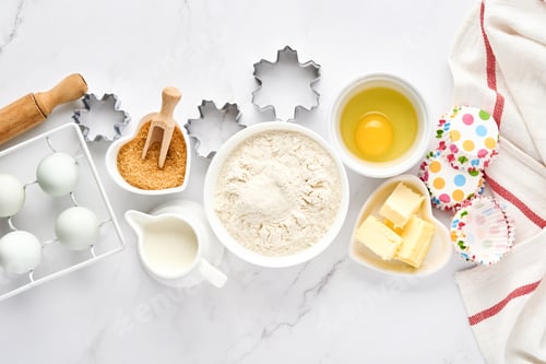 Preview: Baking background with flour, eggs, kitchen tools, utensils and cookie molds on white marble table.