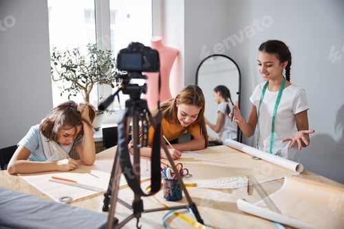 Preview: Adorable girls recording video for sewing blog in workshop