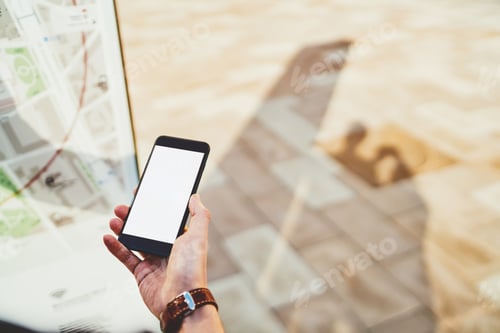Preview: Cropped image of male hand holding smartphone with mock up screen copy space area for advertising
