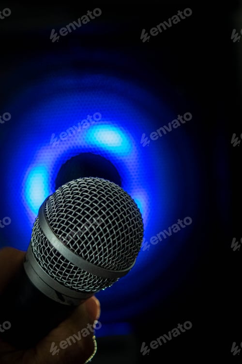 Preview: Vertical shot of a person holding a microphone on a dark blue background