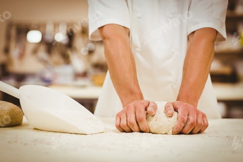 Preview: Baker kneading dough at a counter in a commercial kitchen