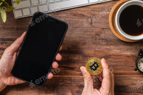 Preview: hand holding mobile and bitcoin crypto currency to trading in stock market.defi on blockchain