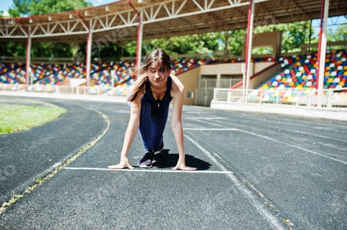 Preview: Portrait of a strong fit girl in sportswear running in the stadium.