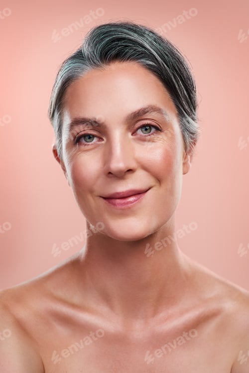 Preview: Studio portrait of a beautiful mature woman posing against a peach background