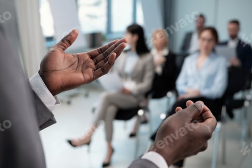 Preview: Hands of young African American coach explaining data to audience during presentation of company