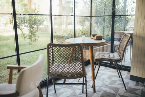 Preview: Cozy light interior with table and wooden chair standing near big window.