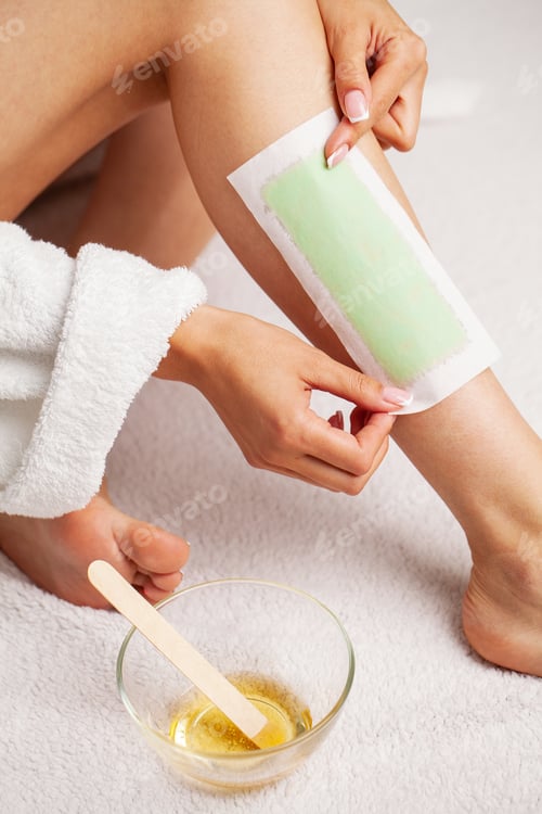 Preview: Waxing woman leg with wax strip at beauty spa