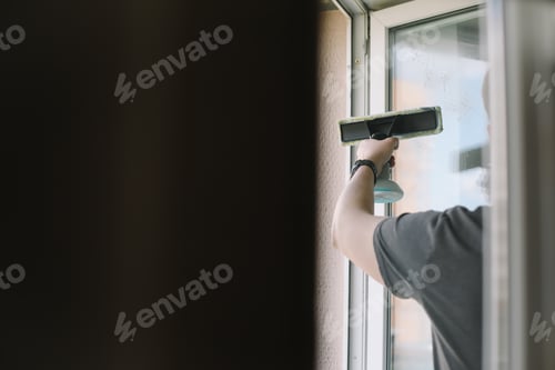 Preview: Man washing and cleaning window at home. Housework and housekeeping, home hygiene