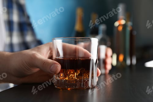 Preview: Men holding glasses of whiskey at the bar, space for text