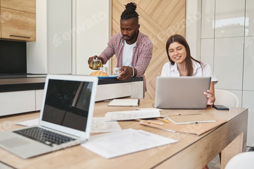 Preview: Male with infuser teapot and busy female with laptop