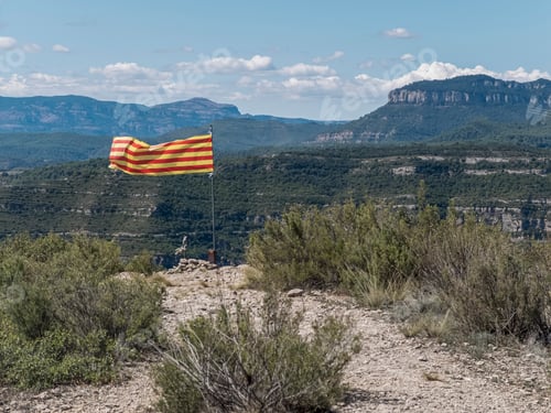 Preview: A Catalonia waving flag on top mountain