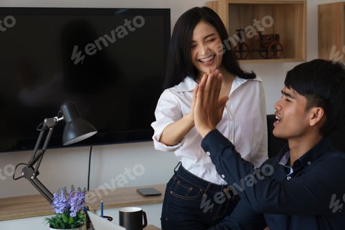 Preview: Happy Asian business team high-fiving in home office.