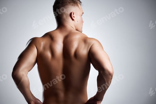 Preview: Studio shot of a muscular young man posing against a grey background