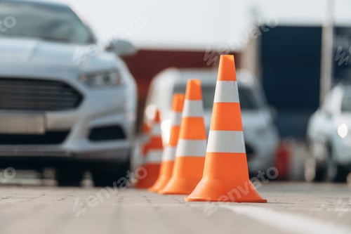 Preview: Car is on the parking lot with orange colored cones, driving school conception