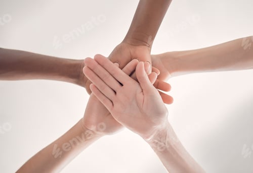 Preview: Group of diverse businesspeople piling their hands together in an office at work. Business professi