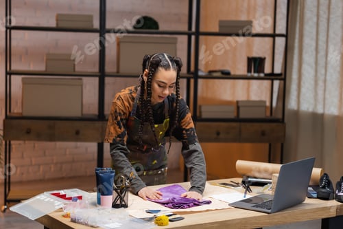 Preview: African american craftswoman putting cloth on sewing pattern in workshop