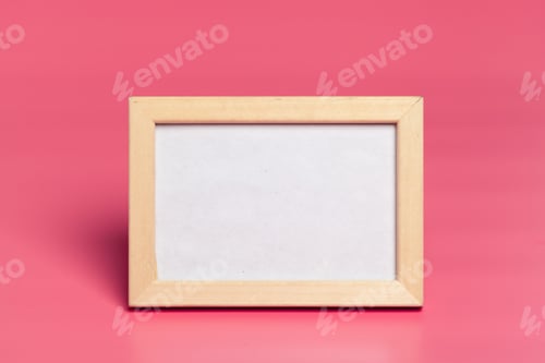 Preview: Empty wooden frame on a vibrant pink background waiting for a picture